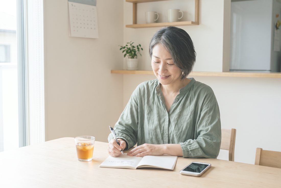 自宅で書きとめる女性